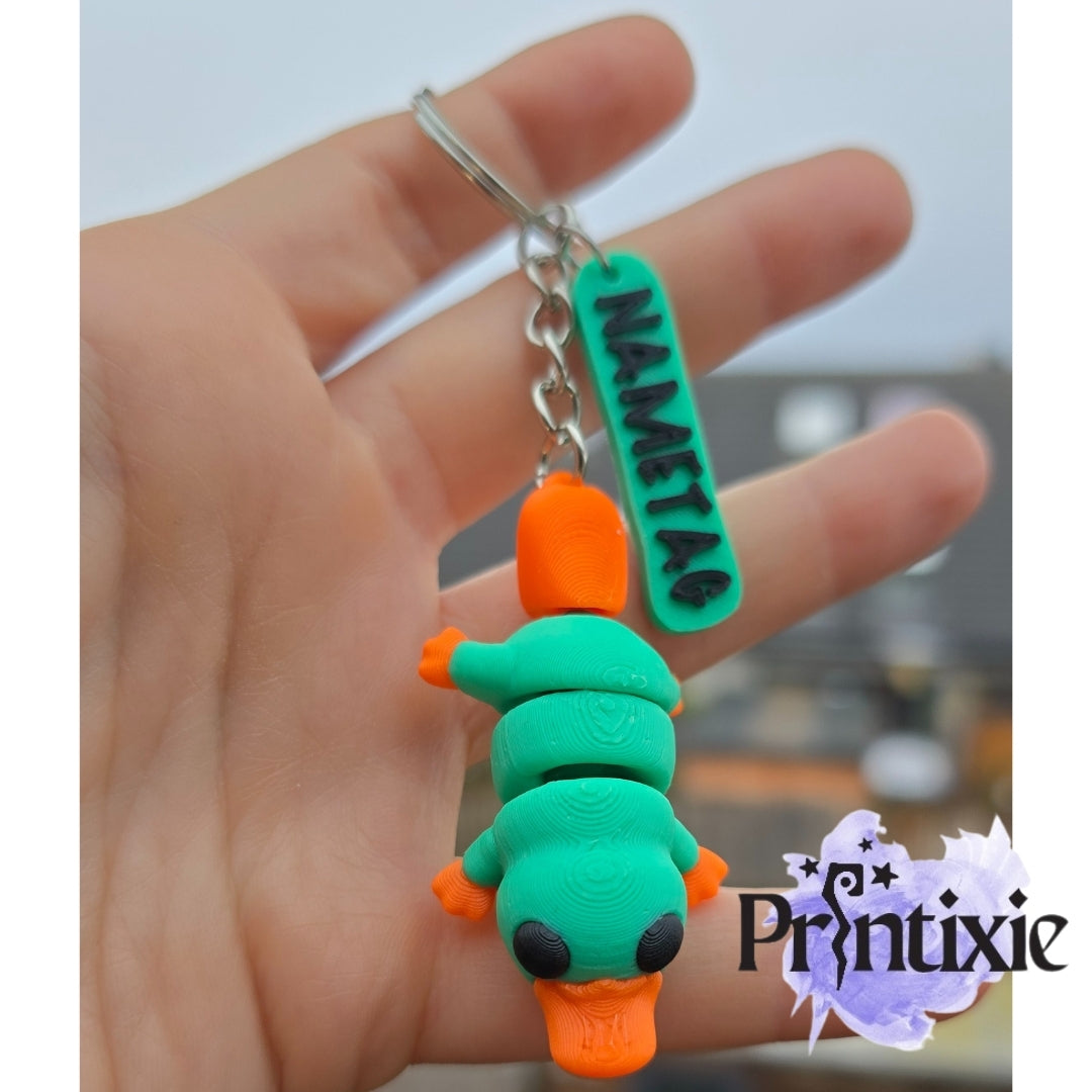Tiny Platypus – a cute and flexible 3D printed keychain with nametag. Made by Printixie