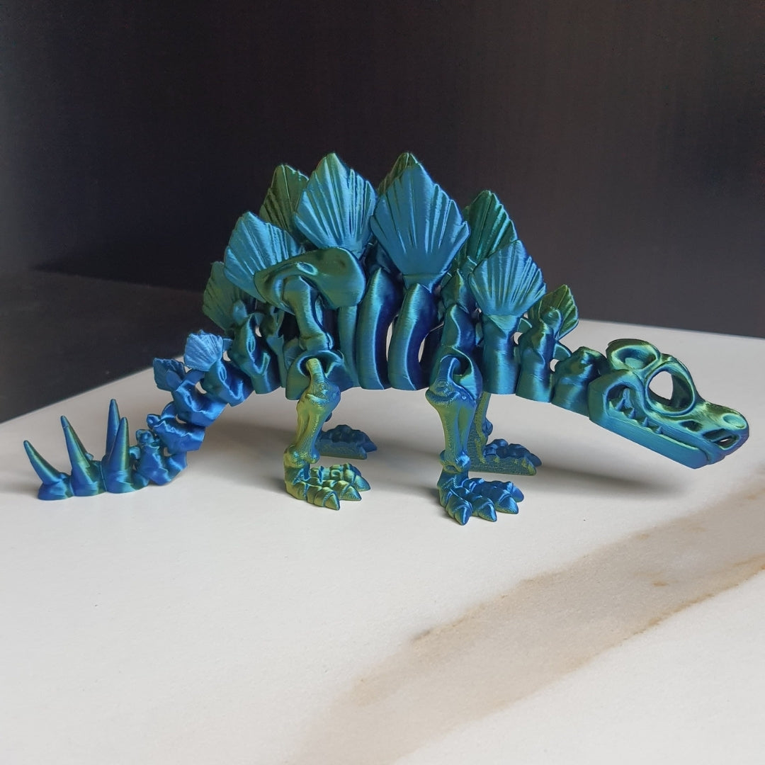 A 3D-printed blue Stegosaurus dinosaur toy with articulated joints